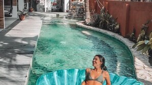 A person relaxing in a pool with a large inflatable shell.