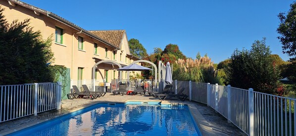 Alberca al aire libre y camastros 