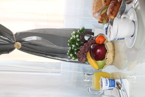 A breakfast table with a variety of food items including fruits, a sandwich, and a cup of coffee. - B&B Carpe Diem (Rome)
