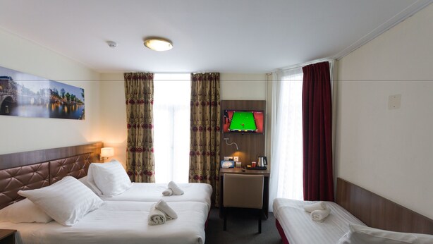 A hotel room with two beds, a desk, a television, and a painting on the wall. - Hotel Park Plantage (Amsterdam)
