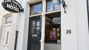 A hotel entrance with a black door, a sign reading "Park Planchage Hotel", and the number 26 on the wall. - Hotel Park Plantage (Amsterdam)