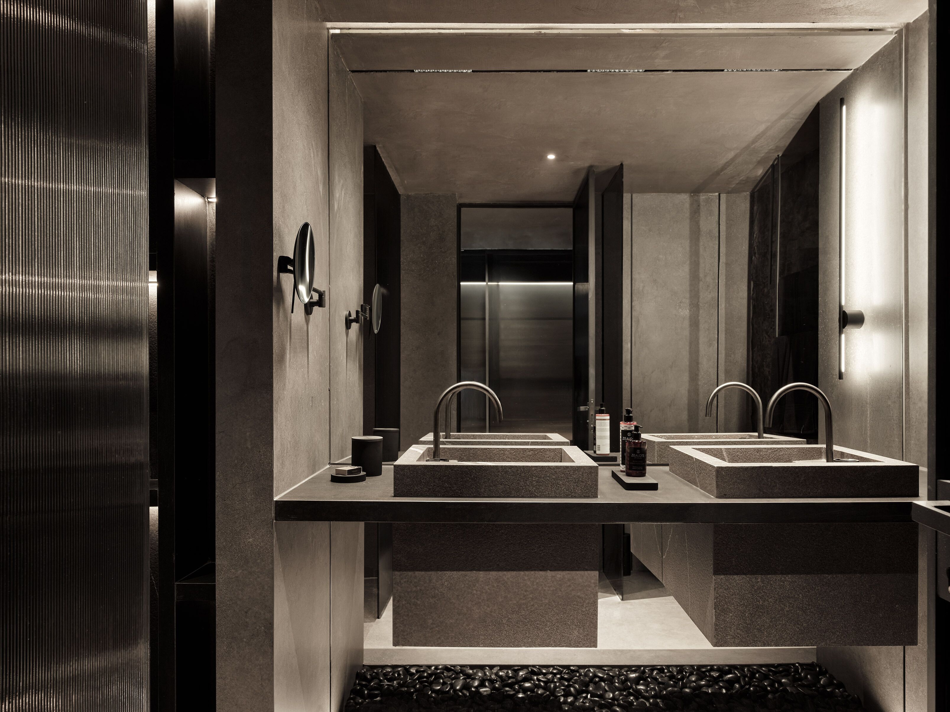 A modern bathroom with two sinks, a mirror, and a towel rack.