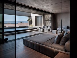 Une chambre moderne dotée d’un grand lit, d’un coin salon et offrant une vue sur l’extérieur.