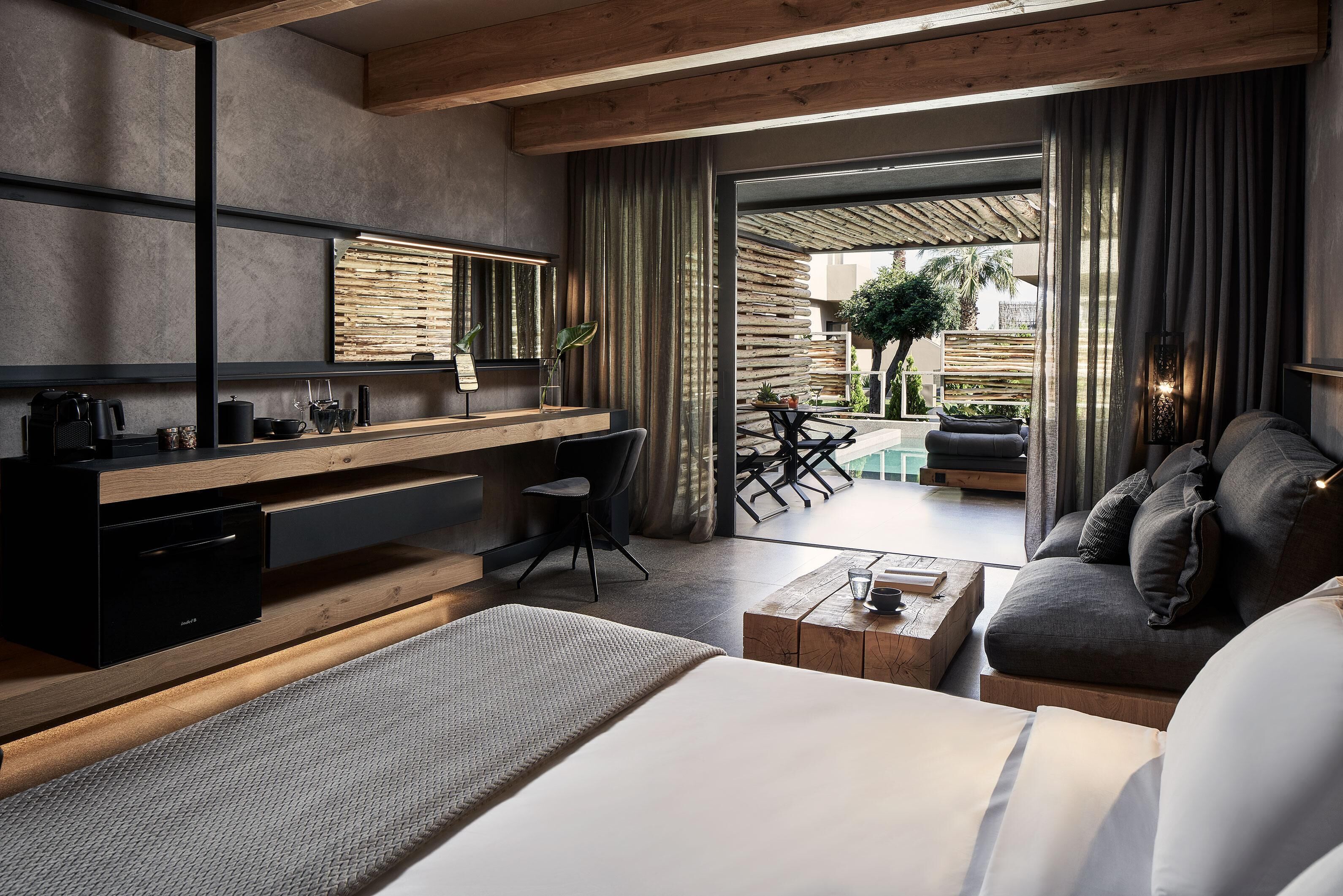 Una habitación de hotel moderna con un escritorio de madera, un sofá cómodo y una cama.