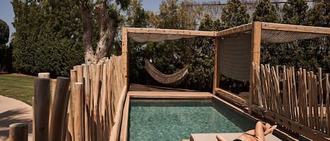 Una piscina al aire libre, camas de piscina gratis, sombrillas