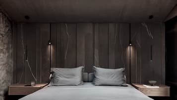 A modern bedroom with a large bed, two bedside tables, and a skylight.