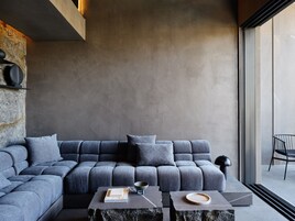 A modern living room with a grey sectional sofa, a coffee table, and a side table.