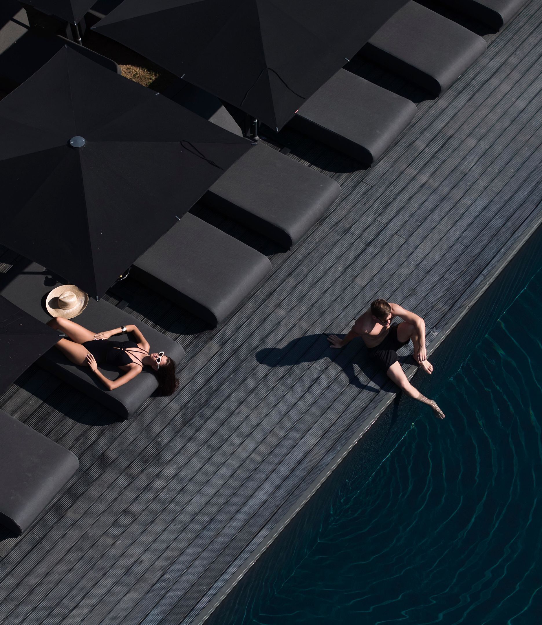 Una piscina al aire libre, camas de piscina gratis, sombrillas