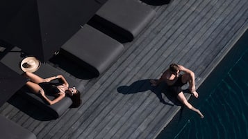 Una piscina al aire libre, camas de piscina gratis, sombrillas