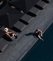 Una piscina al aire libre, camas de piscina gratis, sombrillas