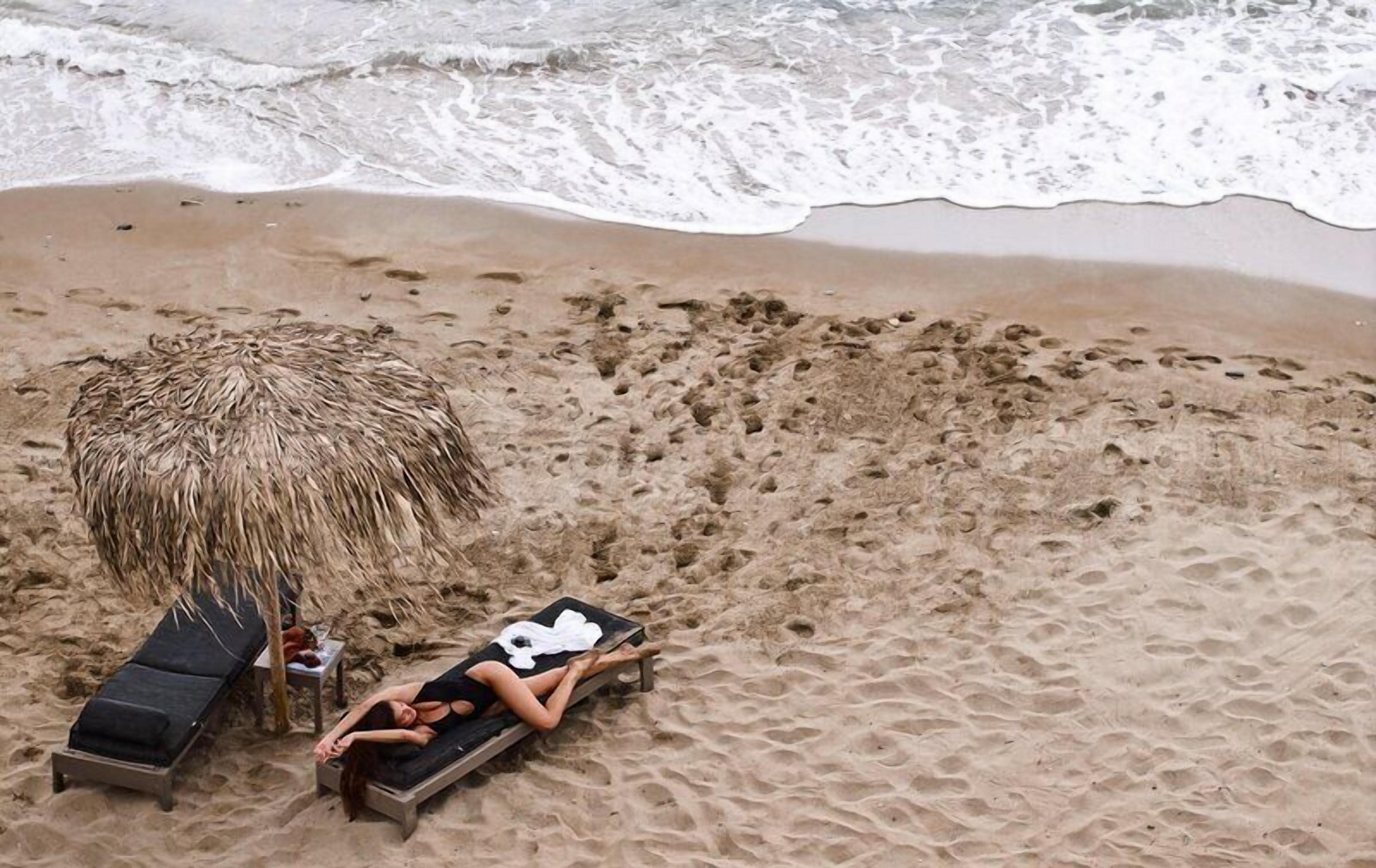 En la playa, sillas reclinables de playa, sombrillas