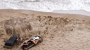 En la playa, sillas reclinables de playa, sombrillas