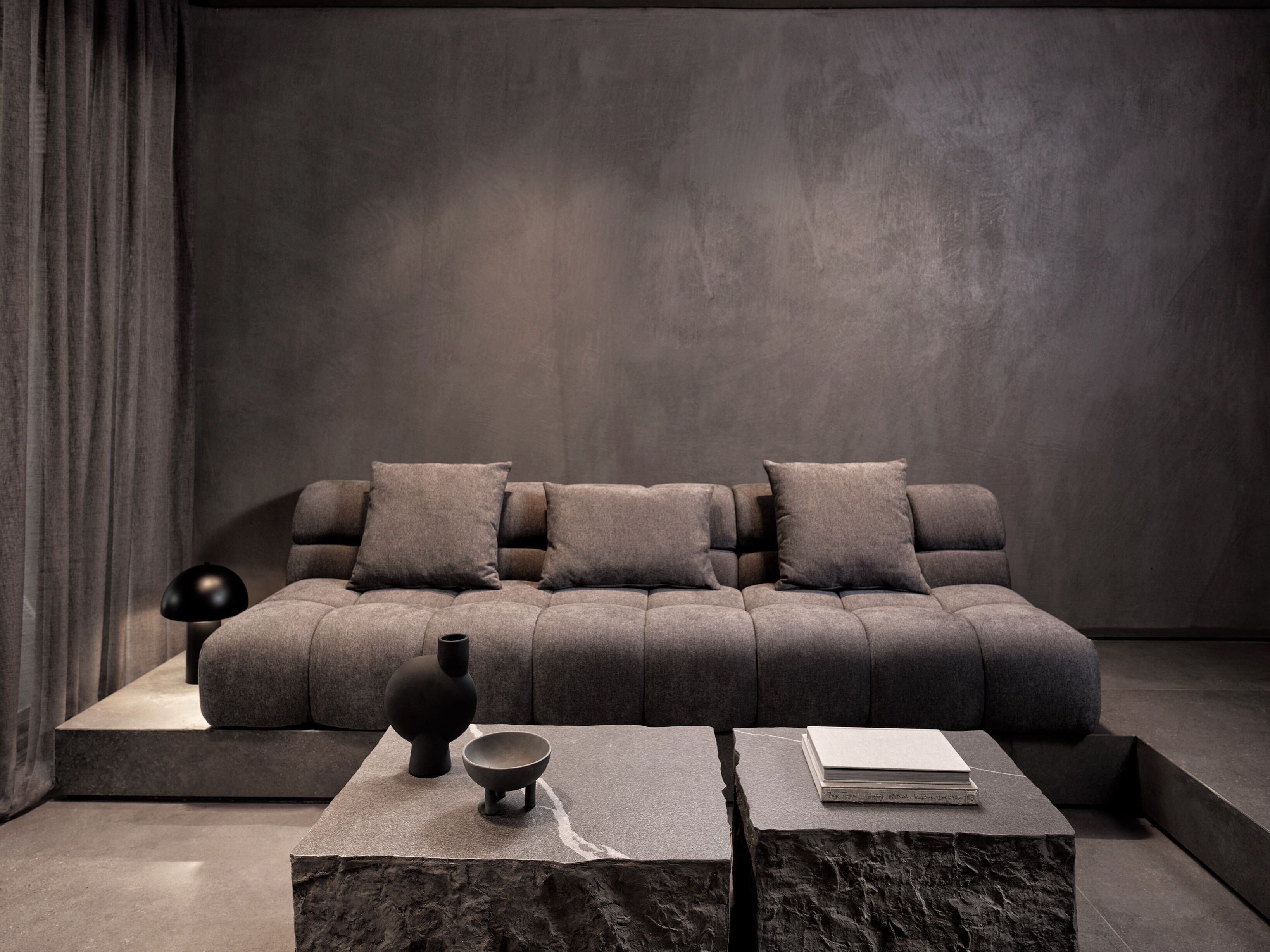 Una sala de estar moderna con un sofá modular, una mesa de centro y objetos decorativos.