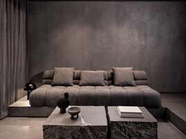 Una sala de estar moderna con un sofá modular, una mesa de centro y objetos decorativos.