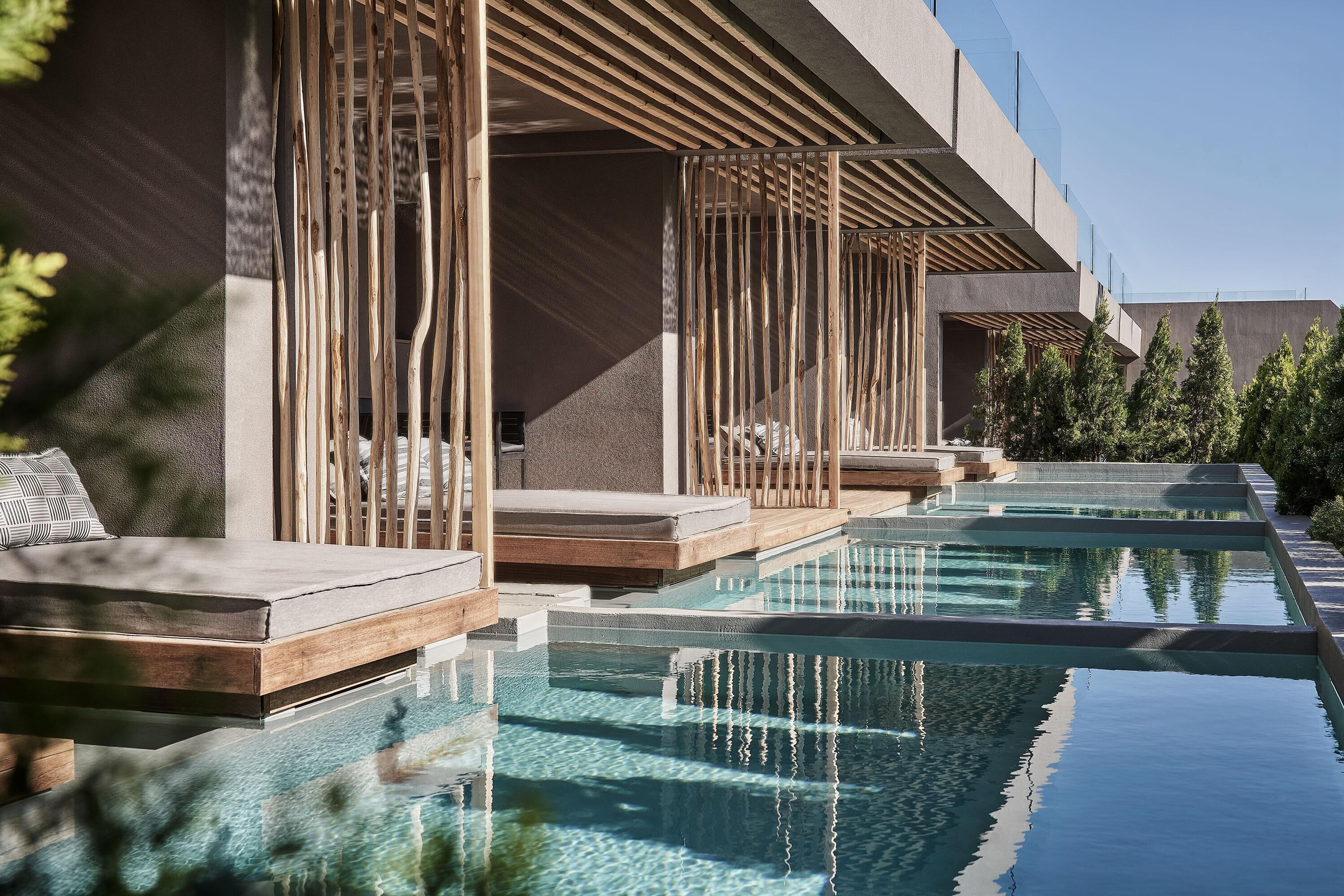 A modern outdoor pool area with tiered seating and a clear view of the sky.