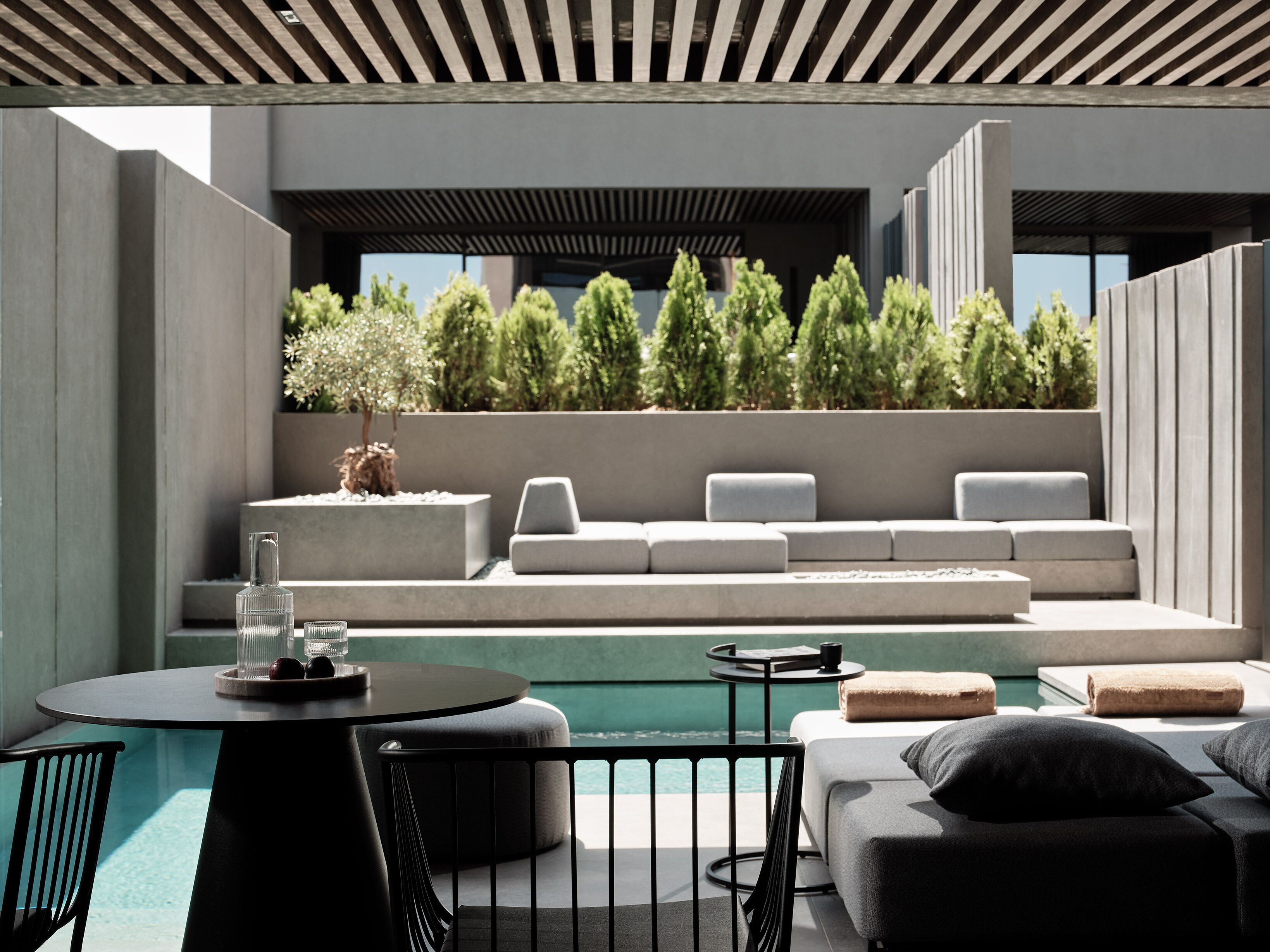 Un espace extérieur moderne, aménagé avec une piscine, une table ronde et une chaise.
