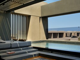 Um interior moderno com piscina, escadas para uma área de estar e vista para o exterior.