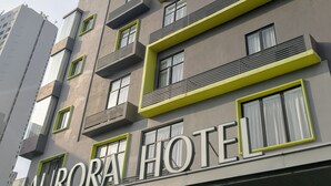 Un hotel de varios pisos con balcones y un cartel que dice "AURORA HOTEL".