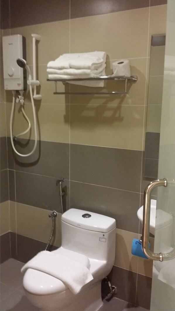 A modern bathroom with a toilet, a shower, and a towel rack. - Aurora Hotel (Malacca City)