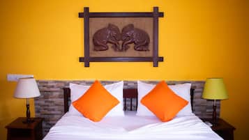 Een hotelkamer met een bed, twee nachtkastjes en een wanddecoratie van twee olifanten.