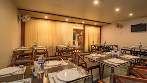A dining area with multiple tables set for meals, equipped with plates, cutlery, and water bottles. - Uddhav Vilas (Udaipur)