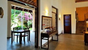 An indoor area with a dining table and chairs, a framed picture, and a staircase leading to a second floor. - Imagine Villa Hotel (Kamburugamuwa)
