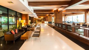 A spacious lobby with a long reception desk, seating area, and large windows. - Laemtong Service Apartment (Si Racha)