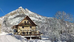 Ein Chalet-Hotel mit Holzfassade, einem Balkon und Bergblick.