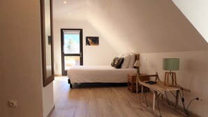 Ein Schlafzimmer mit einem Bett, einem Nachttisch, einer Lampe und einem Fenster.