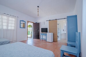 A bedroom with a bed, a desk, a television, and a bathroom with a shower. - La Molinera Bungalows (Arcos de la Frontera)