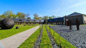 A building with a long, straight pathway leading to a covered area with a blue roof. - Loire & Sens (Les Garennes-sur-Loire)
