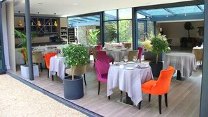 An indoor dining area with tables and chairs, potted plants, and a view of the outdoors. - Loire & Sens (Les Garennes-sur-Loire)