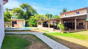 A hostel with a swimming pool, outdoor seating, and a garden area. - Gipsy Ranch Rooms - Hostel (Cabarete)