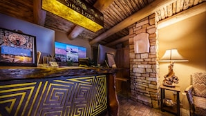 A reception area with a wooden reception desk, a stone wall, and a mounted television.