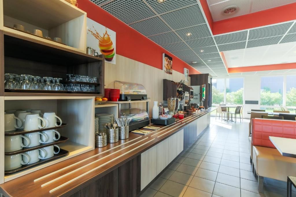 A restaurant with a buffet counter, seating area, and large windows.