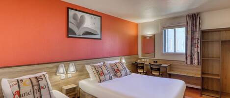 A hotel room with two beds, a desk, a chair, a wardrobe, and a window with curtains.
