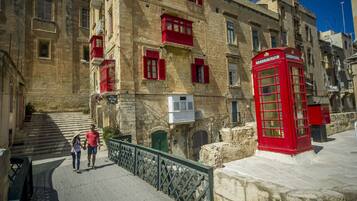 Un bâtiment historique doté de fenêtres à encadrement rouge et d’une cabine téléphonique rouge.