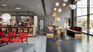 A modern bar area with seating and a bar counter, large windows, and a clean, contemporary interior design. - Living Hotel Frankfurt (Frankfurt)