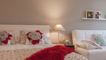 Ein ordentlich eingerichtetes Schlafzimmer mit einem Bett, einem Nachttisch, einer Lampe und einem Sofa.