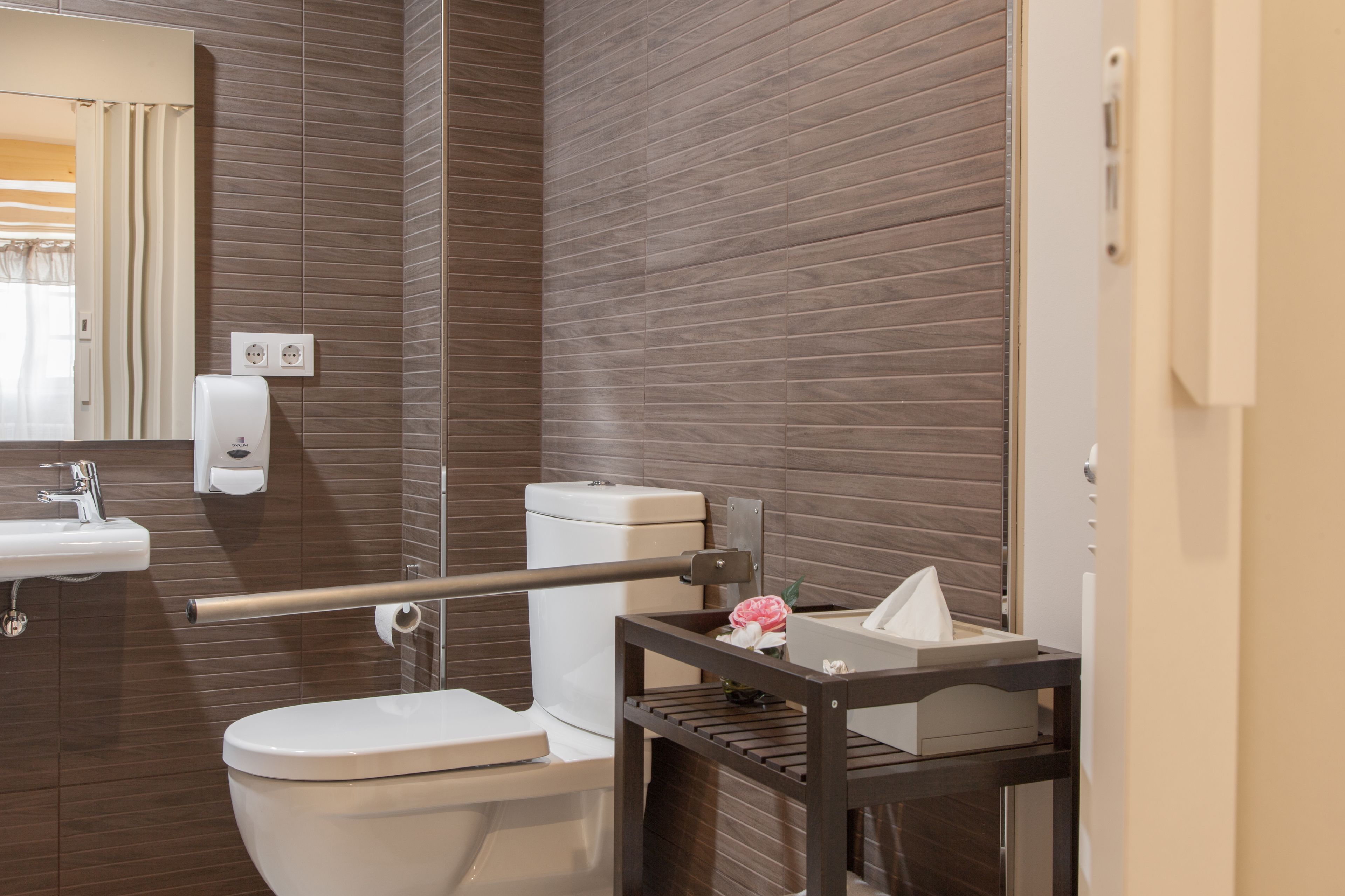 Une salle de bain moderne équipée de toilettes, d’un lavabo et d’un miroir.
