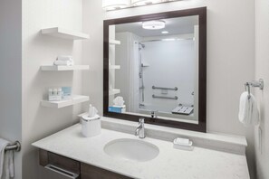 A modern bathroom with a large mirror, white marble countertop, and a built-in shower. - Hampton Inn & Suites by Hilton Atlanta Perimeter Dunwoody (Atlanta)