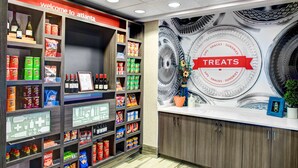 A well-organized snack and beverage section with a variety of products, including bottled drinks and packaged snacks. - Hampton Inn & Suites by Hilton Atlanta Perimeter Dunwoody (Atlanta)