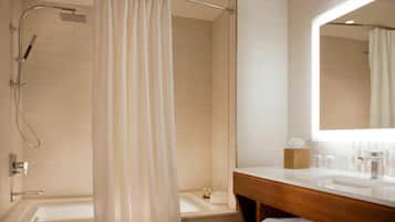 Un bagno moderno con doccia, vasca, mobile lavabo con specchio e porta asciugamani.