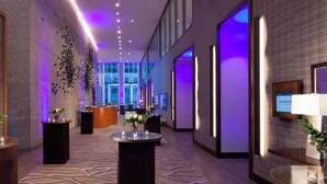 A modern hotel lobby with a reception desk, seating areas, and a large window offering a view of the cityscape. - The Westin Dallas Downtown (Dallas)