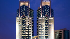 A modern hotel with twin towers, each featuring multiple floors and balconies.