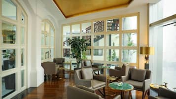A spacious lobby with high ceilings, large windows, and comfortable seating areas.