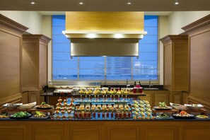 Enjoy a diverse spread of international cuisine at our hotel's buffet, featuring salads, appetizers, and refreshing drinks.