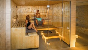 Uma sauna com bancos de madeira e paredes de vidro.