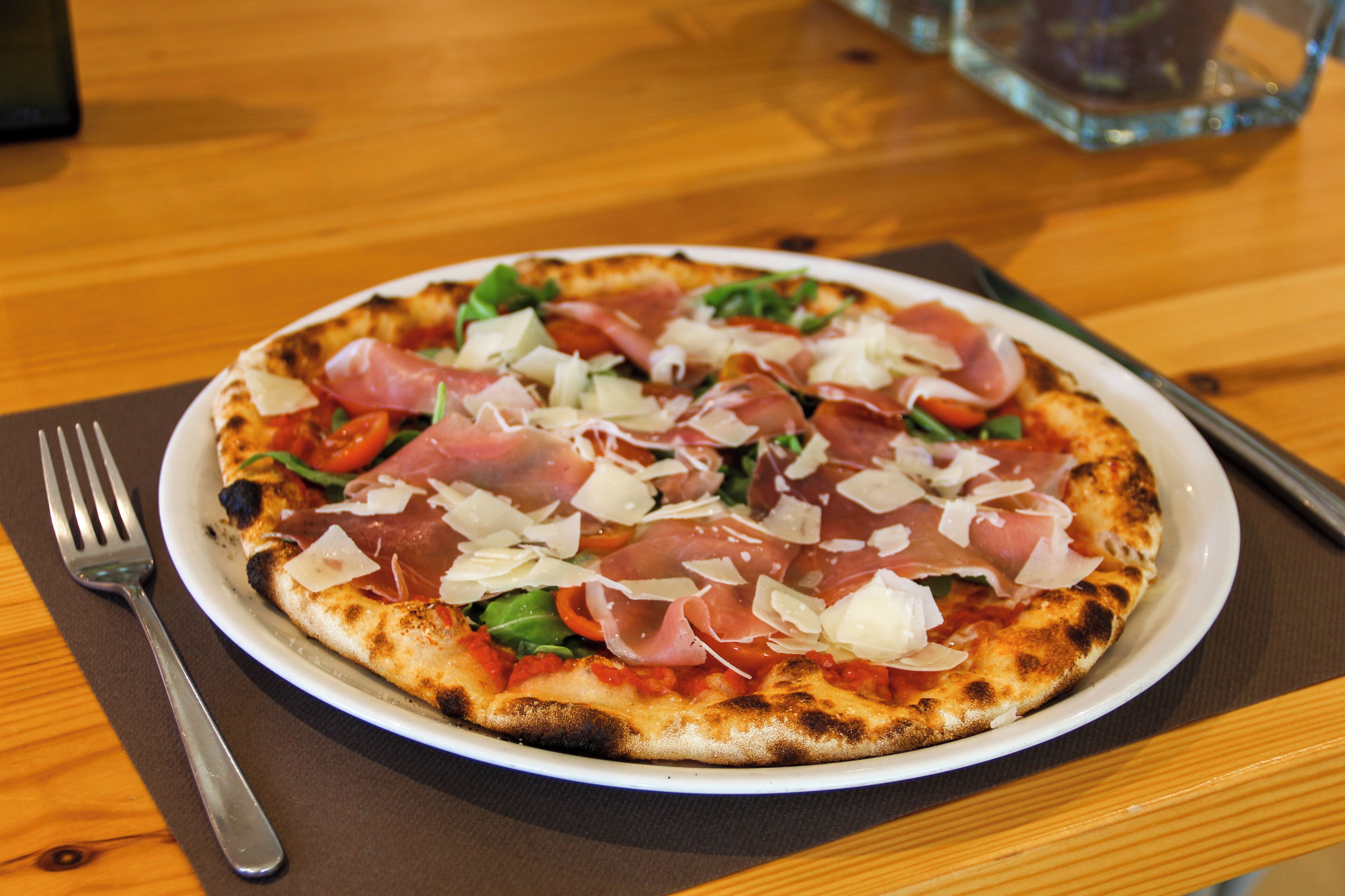 A pizza with various toppings on a white plate.