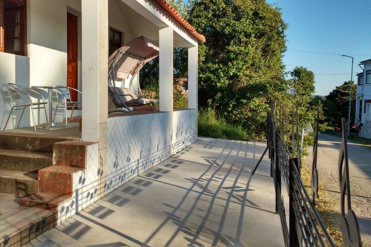 Un espacio exterior cubierto con escalones que conducen a una terraza, una silla y una mesa.